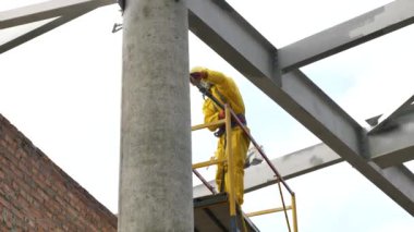 Bir adam metal yapılar boyuyor. Metal için ateş tedavisi.