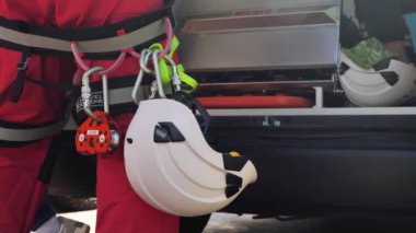 Kurtarıcı. Kemerde kask ve ekipman asılı. Kurtarma işlemi
