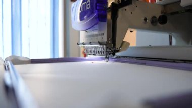 Tekstil endüstrisinde tekstil fabrikalarında şirket logosu işleme sürecinde nakış makinesi. Kumaş endüstrisi için dokuma makinesi. Dikiş atölyesi ya da giysi fabrikası.