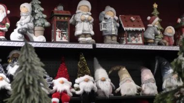 Bir sürü yeni yıl oyuncağı, süslemesi, balosu. Yeni yıl hediyeleri, mağazanın rafındaki Noel ağacı için süslemeler. Yeni yıl oyuncakları vitrinde.