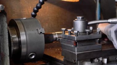 Torna tezgahının yakın plan pirinç şaft parçaları ve talaşları. Torna tezgahında metal çalışma süreci.