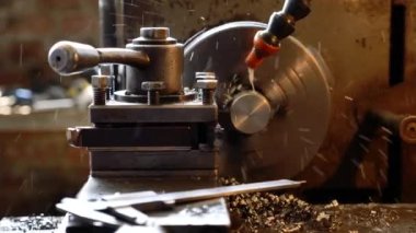 Torna tezgahının yakın plan pirinç şaft parçaları ve talaşları. Torna tezgahında metal çalışma süreci.