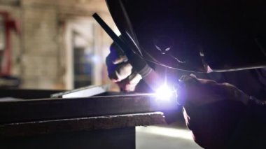 Kaynakçının kaynakçı parçalarını yarı otomatik kaynak makinesiyle yakın çekimde. Ağır sanayi fabrikasında çalışan bir işçi sıkı çalışmasını yapıyor. Sanayi tarzı ve iş.