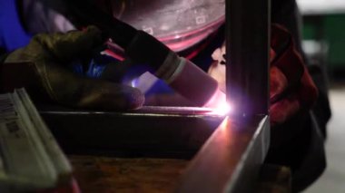 Kaynakçının kaynakçı parçalarını yarı otomatik kaynak makinesiyle yakın çekimde. Ağır sanayi fabrikasında çalışan bir işçi sıkı çalışmasını yapıyor. Sanayi tarzı ve iş.