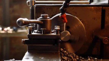 Torna tezgahının yakın plan pirinç şaft parçaları ve talaşları. Torna tezgahında metal çalışma süreci.