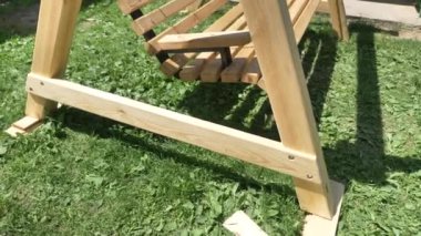 Bahçedeki yeşil çimlerde ahşap salıncak. Bahçe salıncağı.