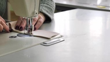 Dikiş. Yakın plan. Terzi dikiş makinesine kumaş dikiyor. Dikiş makinesinin iğnesi hareket halinde. Giysi fabrikasında çalışma süreci.