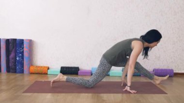 Atletik kadın ışıkla dolu bir odada yoga yapıyor, kadın yoga pozları veriyor, amuda kalkıyor..