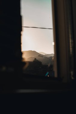 Beautiful sunset over the mountains shot trough a window.