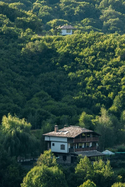 Dağda, güneşin altında eski bir klasik ev..