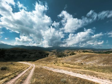 Tepelerde destansı gökyüzü ile gezici fotoğrafçılık.