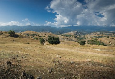 Geniş açı manzaralı yarı bulutlu, yarı berrak ve güneşli tepeler..