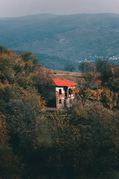 Eski bir evi ve arkasında büyük bir dağı olan güzel bir manzara..