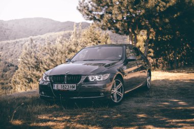 Bulgaristan - 10 02 2024: Gri BMW 3 serisi dağlarda fotoğraf çekimi.