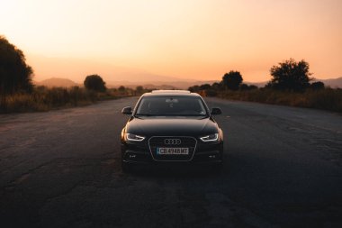 Bulgaristan - 10 02 2024: Siyah Audi S4 arka planda güzel manzarayla terk edilmiş havaalanının ortasına park etti.