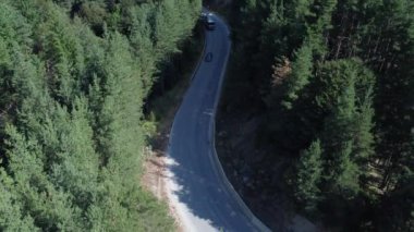 Bulgaristan - 07 26 2024: Orman yolunda giden bir arabanın 4K 30fps 'inde İHA ile video çekmek.