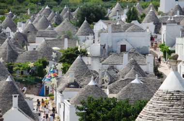Alberobello, İtalya 'da geleneksel beyaz evleri ve çatıları olan eski köy manzarası 