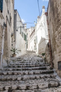 Dar sokaklar üst katta ve çiçekler Matera, Puglia, İtalya 'da.