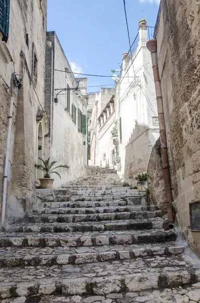 Dar sokaklar üst katta ve çiçekler Matera, Puglia, İtalya 'da.