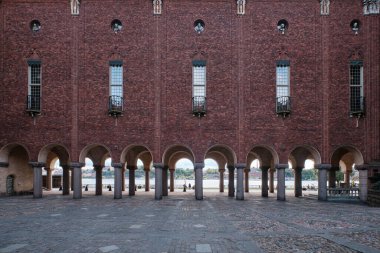 Stockholm, İsveç - Eylül 2022: Riddarfjrden rıhtımındaki belediye binasında sütun kemeri ve tuğla cephesi