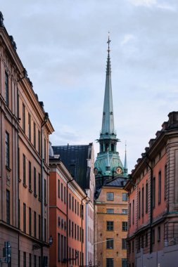 Stockholm, İsveç - Eylül 2022: Eski Şehir Gamla Stan veya Staden Mellan Broarna 'nın renkli binaları, Alman Kilisesi' nin çan kulesi (Sankta Gertruds kyrka)