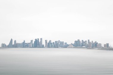 Doha, Katar - Nisan 2023: Doha gökdelenlerinin panoramik şehir manzarası. Ufukta Katar 'ın finansal ticaret bölgesinin gelecekteki ufuk çizgisi görünüyor
