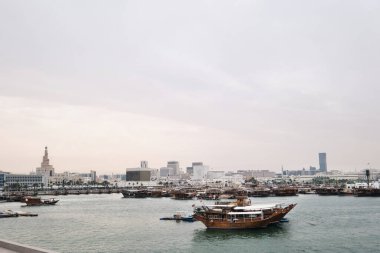Doha, Katar - Nisan 2023: Panoramik şehir manzarası Doha şehir merkezi ve geleneksel tekneler