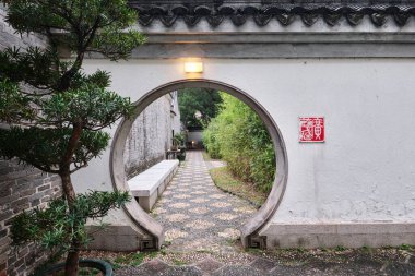 Hong Kong, Çin - 10 Nisan 2023: Geleneksel Çin mimarisi ile Kowloon Duvarlı Şehir Parkı 'nın yuvarlak kapısı