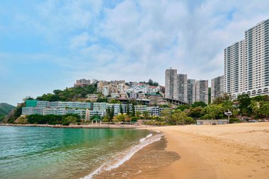 Hong Kong SAR, Çin - Nisan 2023: Yüksek binalar gökdelenler ve Repulse Körfezi 'nde altın kumlu plaj