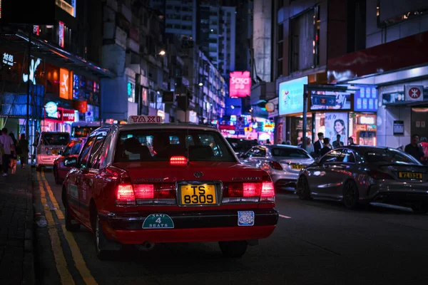 stock image Hong Kong, China - April 10 2023: Red Taxi in a street downtown Mong Kok and neon city lights
