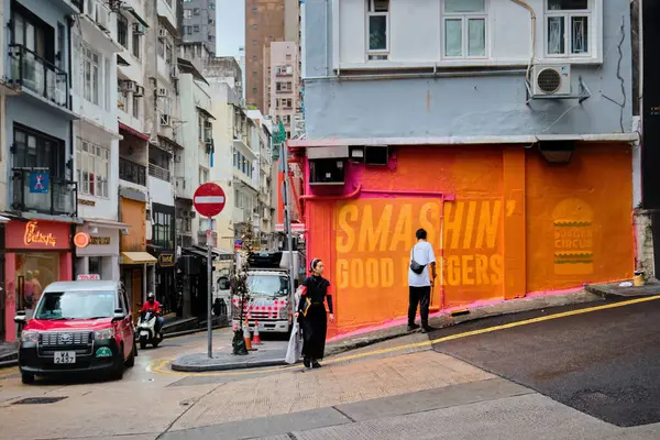 中国香港 2023年4月24日 一名男子将墙壁涂成橙色 以覆盖中心汉堡标志 — 图库照片