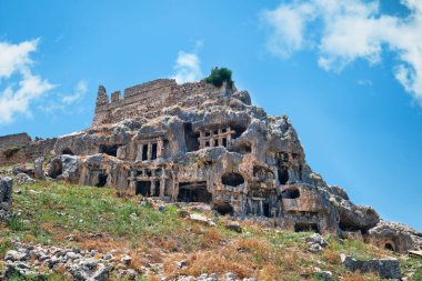Antalya, Türkiye - 18 Temmuz 2023: Antik Tlos kentinin antik kaya mezarları, karmaşık bir şekilde yamaçlara oyuldu