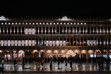 Venedik, İtalya - 9 Kasım 2023: Venedik 'teki San Marco Meydanı' nın insan, restoran ve aydınlık cepheli görüntüsü
