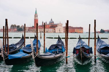 Venedik, İtalya - 9 Kasım 2023: Arka planda Saint Giorgio Maggiore Kilisesi 'nin çan kulesi olan geleneksel gondollar (San Marco seti manzarası)