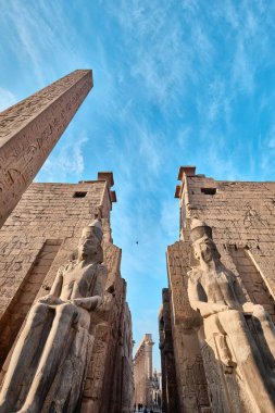 Luxor, Mısır - 26 Aralık 2023: Luxor Tapınağı ana girişi, Dikilitaş ve Ramses II heykelleri ile ilk pilon