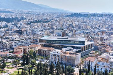 Atina, Yunanistan - 03 Mart 2024: Bernard Tschumi tarafından tasarlanan Akropolis Arkeoloji Müzesi ve Akropolis tepesinden Atina manzarası