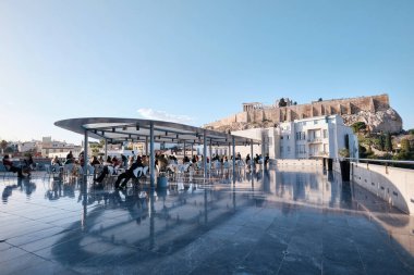 Athens, Greece - March 03, 2024: Restaurant at Acropolis museum with opened terrace and Parthenon view full of customers on sunny day in Greece clipart