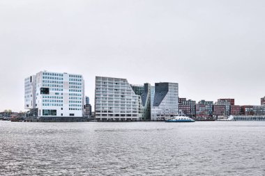 Hollanda, Amsterdam - 10 Nisan 2024: Het IJdok 'taki IJ nehri yanındaki çağdaş ofis binaları