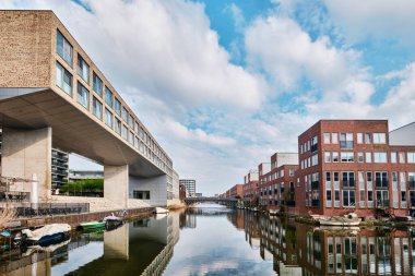 Hollanda, Amsterdam - 10 Nisan 2024: Ijburg İlçesi 'nde Kanal manzaralı Konut Binaları ve tuğla modern mimari