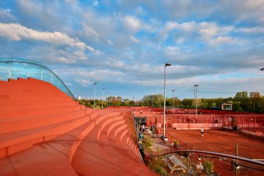 Netherlands, Amsterdam - April 10, 2024: The clubhouse of Tennis IJburg designed by MVRDV. Stepped bleacher style seating on the roof clipart