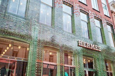 Netherlands, Amsterdam - April 10, 2024: Luxury clothing store Hermes in the luxurious shopping street Hooftstraat. Designed by MVRDV clipart