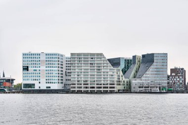 Hollanda, Amsterdam - 10 Nisan 2024: Het IJdok 'taki IJ nehri yanındaki çağdaş ofis binaları
