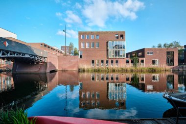 Hollanda, Amsterdam - 10 Nisan 2024: Ijburg İlçesi 'nde Kanal manzaralı Konut Binaları ve tuğla modern mimari