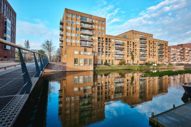 Hollanda, Amsterdam - 10 Nisan 2024: Ijburg İlçesi 'nde Kanal manzaralı Konut Binaları ve tuğla modern mimari