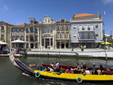 Aveiro, Portugal - May 29, 2024: Tourists in a traditional moliceiro boat in a canal in the city of Aveiro, Portugal. clipart