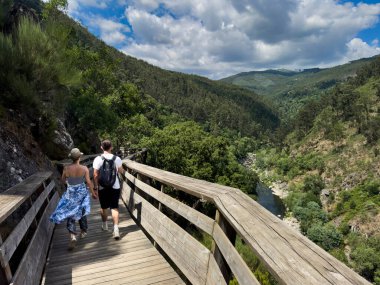 Arouca, Portekiz - 6 Temmuz 2024: Portekiz 'in Arouca kentindeki Paiva Nehri boyunca yürüyen insanlar.