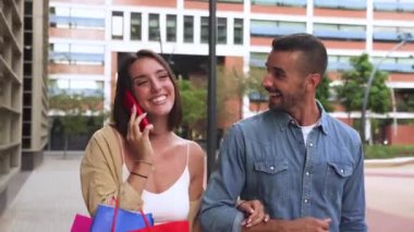 Ortağıyla yürürken gülümseyen genç bir kadın arkadaşça bir telefon görüşmesi yapıyor, dışarıda alışveriş torbaları tutuyor. Genç, beyaz bir çift bir arkadaşını görmeye giderken cep telefonuyla gülüyor ve konuşuyorlardı.