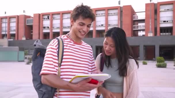 Szczęśliwi Studenci Rozmawiający Śmiejący Się Podczas Przeglądania Notatek Programowych Kampusie — Wideo stockowe