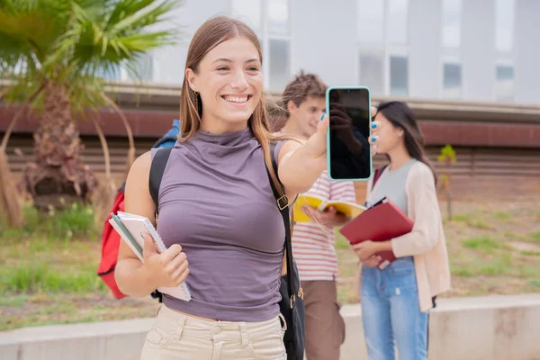 Νεαρή Χαμογελαστή Μαθήτρια Κρατώντας Και Δείχνοντας Μια Άδεια Οθόνη Smartphone — Φωτογραφία Αρχείου
