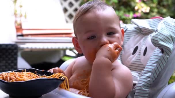 大切な赤ちゃんは 手でスパゲッティを食べる汚い混乱を作ることを楽しんでいます 自家製パスタとトマトソースと面白い赤ちゃん — ストック動画